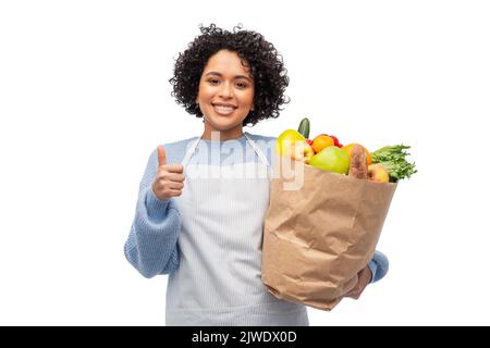 femme en tablier avec nourriture à emporter dans un sac en papier Banque D'Images
