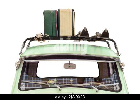 Vue avant d'une vieille voiture avec skis et bagages attachés à une galerie de toit isolée sur un fond blanc Banque D'Images