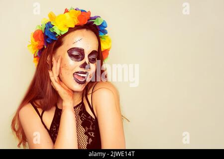 Fête d'Halloween, fille en costume et avec maquillage d'halloween. Une fille dans le sang, avec des cicatrices et un squelette de maquillage. Une fille avec des fleurs sur sa tête Banque D'Images