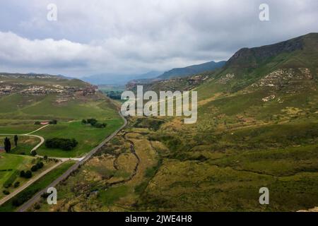 Vue sur l'autoroute traversant une vallée dans les montagnes du Drakensberg de l'État libre d'Afrique du Sud, avec une tempête en hauteur Banque D'Images