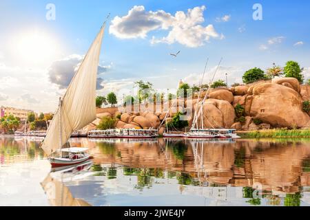 Le bateau navigue sur les rives pittoresques du Nil et les bâtiments traditionnels d'Assouan, en Égypte Banque D'Images