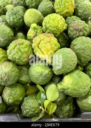 Gros plan d'une pile de limes Kaffir à vendre sur un marché de rue, Bangkok, Thaïlande Banque D'Images