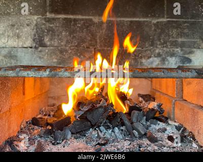 Gros plan d'une charbons brûlants dans un barbecue en briques maison Banque D'Images