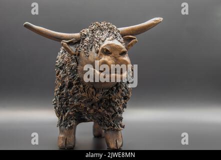 Gros plan détaillé d'une figurine scottish Red highland en argile fabriquée à la main (Bò Ghàidhealach; Hielan coo) avec cornes complètes Banque D'Images