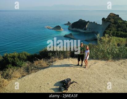 Souriant Homme et femme debout sur une falaise, Cape Drastis, Corfou, Grèce Banque D'Images