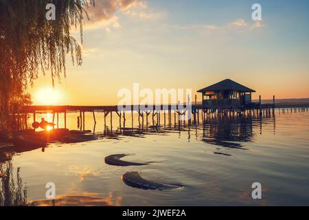 Coucher de soleil sur le lac de mer et ancienne jetée en bois, destination de voyage romantique, paysage de la nature Banque D'Images