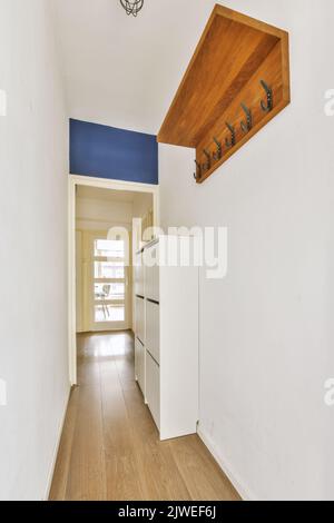 Intérieur moderne plat de style minimaliste avec couloir vide étroit éclairé par des lampes Banque D'Images