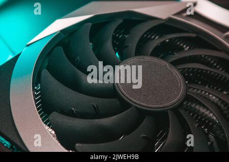 Ventilateur plus froid sur la carte graphique vidéo GPU, gros plan dans une lumière turquoise avec mise au point sélective, détails matériels du PC. Composants de l'ordinateur pour les jeux ou c Banque D'Images