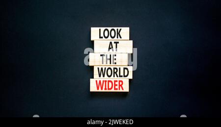 Regardez le symbole du monde entier. Les mots de concept regardent le monde plus large sur des blocs de bois sur un beau tableau noir fond noir. Affaires et look Banque D'Images