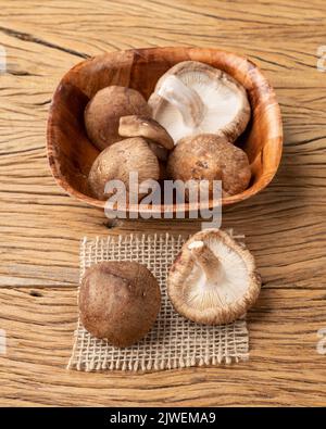 Shitake champignons dans un bol sur une table en bois. Banque D'Images