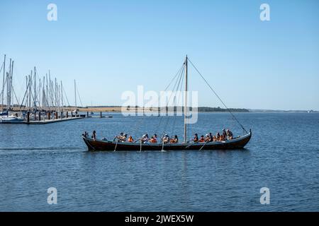 Touristes ramer réplique navire viking sur le fjord au Musée des navires viking, Roskilde, Zélande, Danemark, Europe Banque D'Images