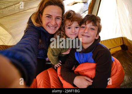 Mère prenant le selfie avec les enfants en tente Banque D'Images