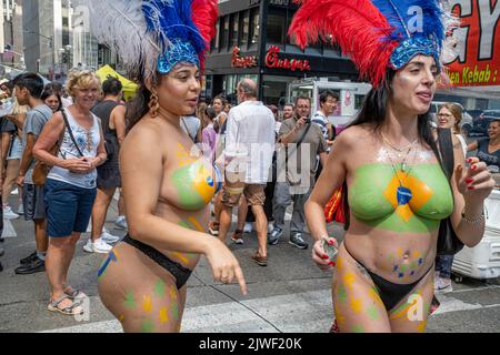 New York, New York, États-Unis. 4th septembre 2022. Foire de la rue Brazil Day à New York. Vendeurs, touristes et New Yorkers sur la Sixième Avenue Little Brazil sur 46th rue. Les dernières années ont vu de la musique, de la danse et d'autres festivités. Cette année purement une foire de rue avec quelques femmes de peinture du corps habituellement trouvé dans Times Square. Ceux-ci montrent le drapeau peint vert et jaune du Brésil. (Image de crédit : © Milo Hess/ZUMA Press Wire) Banque D'Images