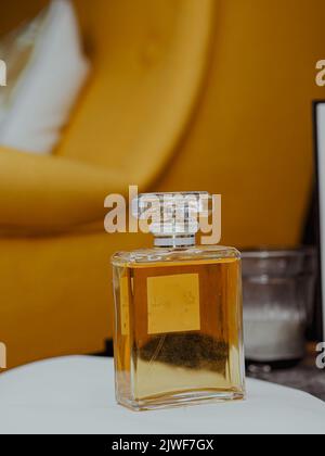 Un cliché vertical d'une bouteille de parfum esthétique claire avec une substance d'or Banque D'Images