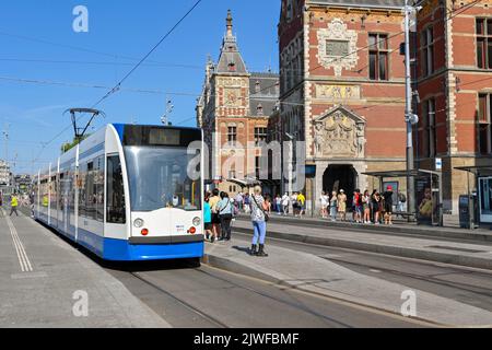 Amsterdam, pays-Bas - août 2022 : personnes descendant d'un tramway électrique Modren à un arrêt de tramway devant la gare centrale de la ville Banque D'Images