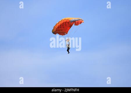 Le skydiver mâle descend sur un parachute Banque D'Images