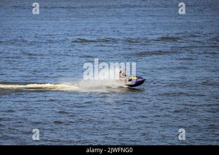 Homme à cheval sur un jet ski sur la rivière Banque D'Images