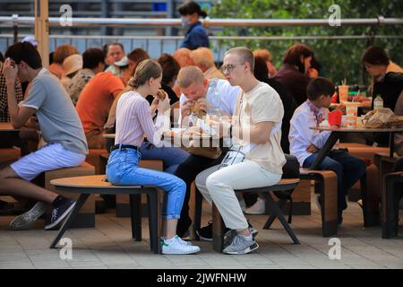 Kiev, Ukraine - 24 août 2021 : les jeunes mangent des hamburgers à McDonalds en plein air Banque D'Images