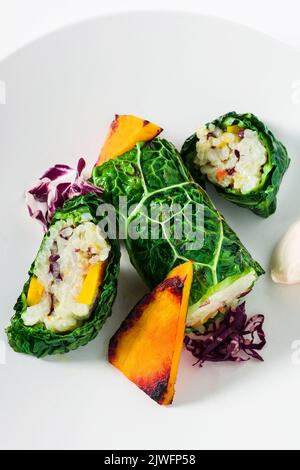 plat de restaurant végétalien : rouleaux de chou de savoie avec riz et légumes cuits au four : citrouille, radis et mayonnaise Banque D'Images