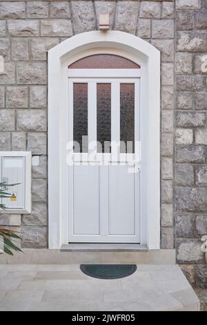 Porte avant en plastique blanc avec verre sur la façade de la maison Banque D'Images