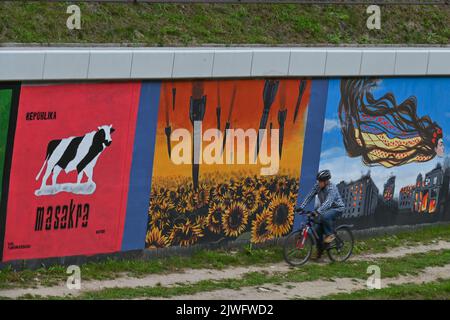 GDANSK, POLOGNE. 05 septembre 2022. Un cycliste passe par une peinture murale pro-ukrainienne près de 30 peintures murales anti-guerre ont été peintes sur le mur à l'arrêt PKM Gdansk Jasien Mapka dans le cadre du projet "en solidarité avec l'Ukraine" lancé par le PKM et l'Académie des beaux-arts de Gdansk. Beaucoup de peintures murales sont liées à Le conflit russo-ukrainien de 2022. Crédit : ASWphoto/Alamy Live News Banque D'Images