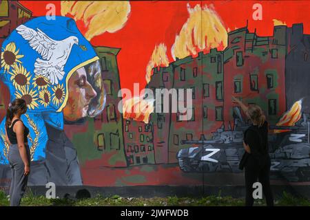 GDANSK, POLOGNE. 05 septembre 2022. Deux jeunes femmes regardent une fresque pro-ukrainienne créée par l'artiste polonaise Maria Morawska. Près de 30 peintures murales anti-guerre ont été peintes sur le mur à l'arrêt PKM Gdansk Jasien Mapka dans le cadre du projet "en solidarité avec l'Ukraine" lancé par le PKM et l'Académie des beaux-arts de Gdansk. Beaucoup de ces peintures murales sont liées au conflit russo-ukrainien de 2022. Crédit : ASWphoto/Alamy Live News Banque D'Images