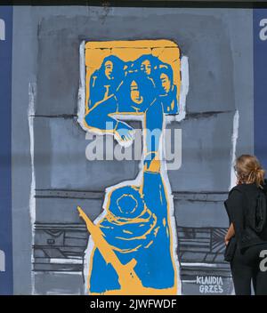 GDANSK, POLOGNE. 05 septembre 2022. Une jeune femme regarde une fresque pro-ukrainienne créée par l'artiste polonaise Claudia Grzes. Près de 30 peintures murales anti-guerre ont été peintes sur le mur à l'arrêt PKM Gdansk Jasien Mapka dans le cadre du projet "en solidarité avec l'Ukraine" lancé par le PKM et l'Académie des beaux-arts de Gdansk. Beaucoup de ces peintures murales sont liées au conflit russo-ukrainien de 2022. Crédit : ASWphoto/Alamy Live News Banque D'Images