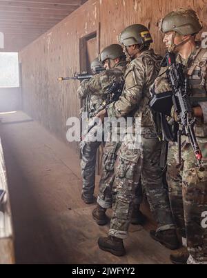 Les soldats d'infanterie de l'armée américaine en formation affectés à la Compagnie Alpha, 2nd Bataillon, 58th infanterie Regiment, 198th brigade d'infanterie, travaillent ensemble pour nettoyer les bâtiments pendant les opérations militaires en terrain urbanisé (MOUT) à leur final FTX 29 août 2022, sur le fort Benning, GA. Banque D'Images