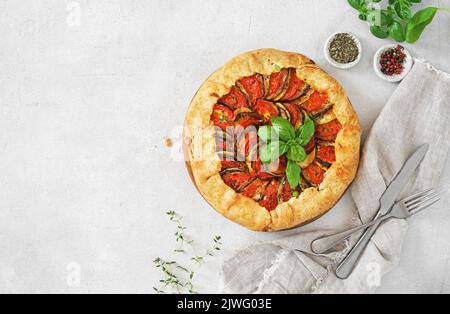 Galette ratatouille avec aubergines, courgettes, tomates sur fond clair. Espace copie, vue du dessus Banque D'Images