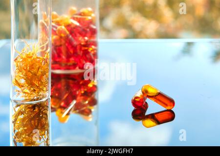 Curcumine sous forme liquide. Capsules à base de plantes, capsules de curcuma aux herbes sur fond neutre avec ombre de feuilles de palmier. Extrait de médecine de fines herbes de curcuma Banque D'Images