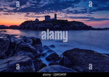 Lever du soleil tôt le matin au-dessus du phare de Nubble, York, Maine. Banque D'Images