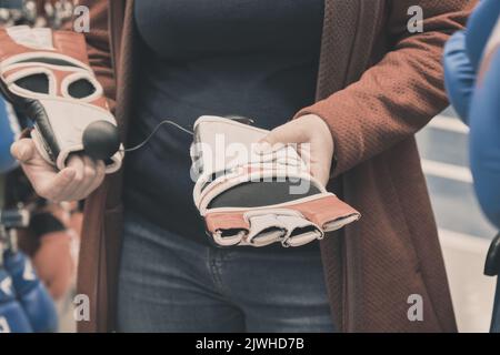 La femme choisit d'acheter des gants pour un mixfight. Gros plan des mains Banque D'Images