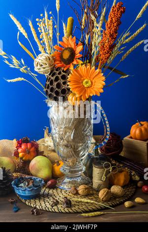 Arrangement floral sur le thème de l'automne sur fond bleu vif. Banque D'Images