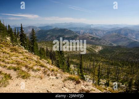 Vue sur Selway-Bitterroot Wilderness depuis la route du couloir de Magruder. Fumée provenant d'un feu lointain visible. Idaho, États-Unis Banque D'Images