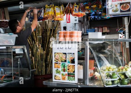 Homme vendant des fruits frais et du jus de canne à sucre dans un magasin de Cabramatta — Sydney, Australie Banque D'Images