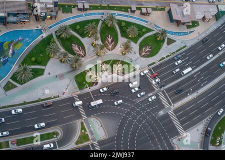 Une vue à grand angle de l'intersection des rues, des marquages de marche, des feux de signalisation et des bordures de trottoir ouest de la baie de Doha Banque D'Images