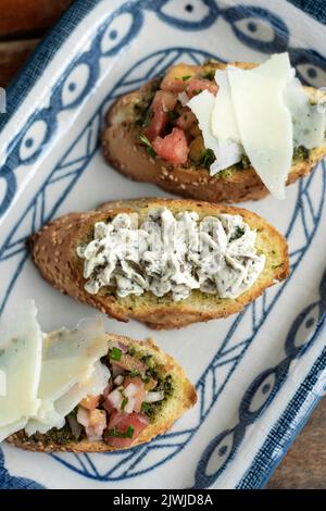 Tapas avec bruschetta et fromage aux herbes crémeux sur toast dans un restaurant rustique Banque D'Images