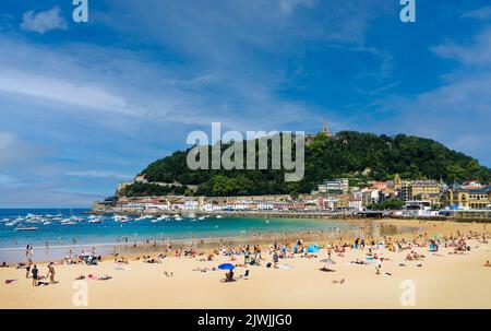 Paysage de la plage de la Concha dans la ville de San Sebastian, dans le pays Basque espagnol, lors d'une journée ensoleillée avec les gens appréciant la plage et le Mont Urgu Banque D'Images