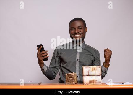 un homme africain heureux avec beaucoup d'argent se réjouit Banque D'Images