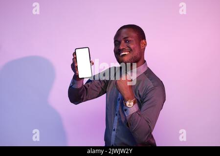 homme africain excité montrant son écran de téléphone Banque D'Images