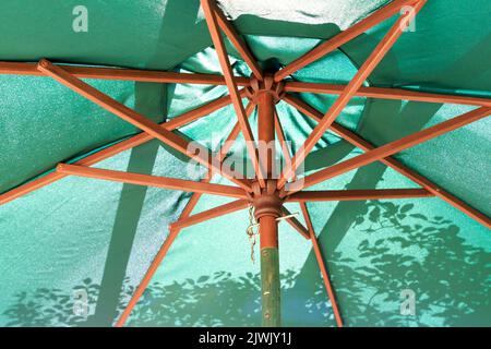 Vue sur le dessous d'un parasol avec motifs d'ombre créés par la lumière du soleil Banque D'Images