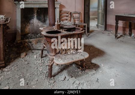 Septembre 2022, Italie. Urbex vieux poêle en fonte rouillée dans une maison abandonnée Banque D'Images