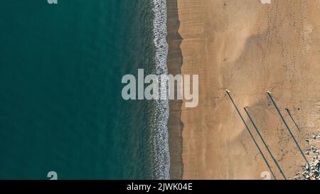 Descente aérienne le long d'une plage de sable au large de la côte galloise Banque D'Images