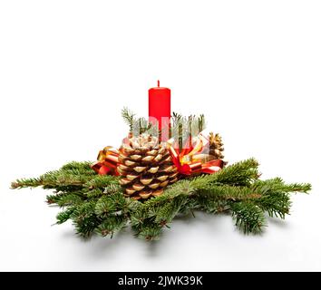 Décoration centre de table de Noël avec une bougie de couleur rouge et le sapin de feuilles d'arbres. Banque D'Images