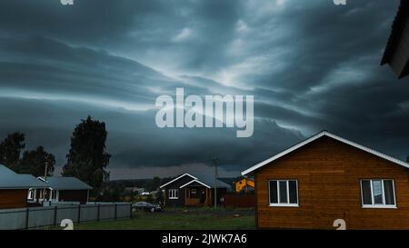 Thunderbolt sur la maison dans le village et sombre ciel orageux sur le fond. Banque D'Images