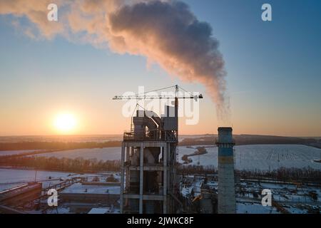Vue aérienne de la tour de l'usine de ciment avec une structure en béton élevée dans la zone de production industrielle au coucher du soleil. Industrie manufacturière et industrie mondiale Banque D'Images
