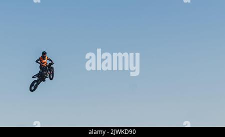 Sports extrêmes. Vélo cavalier saut haut dans l'air. Prise de vue panoramique. Ciel bleu comme arrière-plan. Photo de haute qualité Banque D'Images