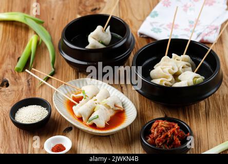 Odeng Guk avec divers bouillon de bouillon, épicé, viande et poulet. Servi avec Kimchi, Sesame Seed et Gochugaru. Sur une table en bois Banque D'Images