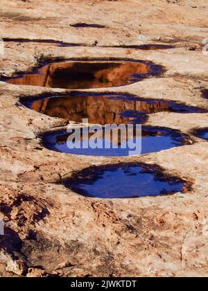 L'orgue, un monolithe de grès dans les tours du palais de justice, se reflète dans un pothole d'eau de pluie dans le parc national d'Arches, Moab, Utah. Banque D'Images