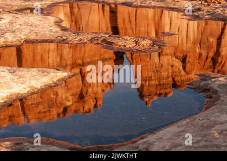 L'orgue, un monolithe de grès dans les tours du palais de justice, se reflète dans un pothole d'eau de pluie dans le parc national d'Arches, Moab, Utah. Banque D'Images